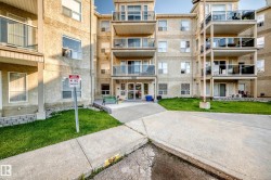 Multi-story building exterior featuring textured stucco siding and multiple private balconies with glass railings - 