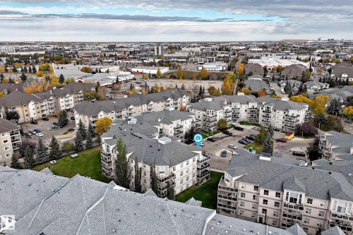 Aerial overview of a multi-building residential complex featuring pitched shingle roofs and multiple balconies - #201 9760 174 St Nw, Edmonton, AB - Outdoor With View