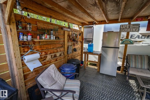 Outdoor covered patio area featuring wood plank walls and a wood beam ceiling - 200 12272 Township Road 602, Rural Smoky Lake County, AB 