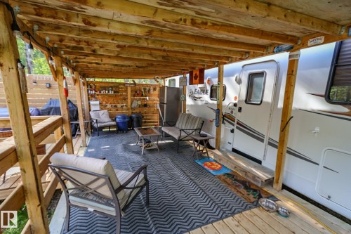 Expansive wood-finish decking featuring an overhead wood-beam pergola - 200 12272 Township Road 602, Rural Smoky Lake County, AB 
