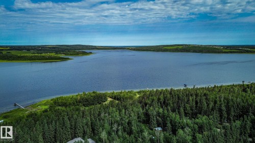 Expansive lakefront property featuring a private dock, surrounded by mature evergreen trees - 200 12272 Township Road 602, Rural Smoky Lake County, AB 