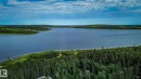 Expansive lakefront property featuring a private dock, surrounded by mature evergreen trees - 200 12272 Township Road 602, Rural Smoky Lake County, AB 