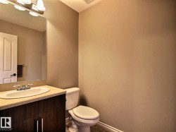 Powder room featuring a dark wood-finish vanity with a light-colored countertop and an undermount sink - 