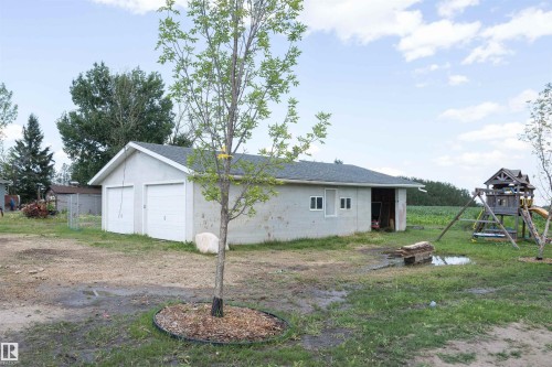 Detached building featuring two garage doors, two windows, and an open bay area - 62503A Hwy 769, Rural Barrhead County, AB - Outdoor