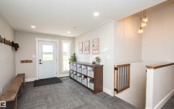 Entryway featuring grey patterned flooring, white trim, recessed lighting, and a built-in storage unit - 