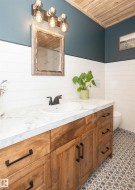 Wood-finish vanity with a white countertop and oval undermount sink, accented by black hardware and a matte black faucet - 