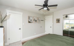 Spacious room featuring light gray walls, white trim, a textured ceiling, a ceiling fan with integrated lighting, and mirrored closet doors - 
