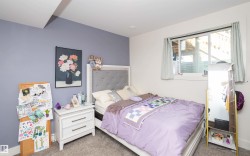 Bedroom featuring a recessed light, soft gray carpeting, and a window with a white frame - 