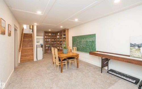 Spacious open area featuring built-in wood bookshelves, recessed lighting, and light-toned carpeting - 62503A Hwy 769, Rural Barrhead County, AB - Indoor Photo Showing Other Room