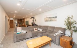 Finished lower level featuring recessed lighting, paneled ceiling, light gray carpeting, and white walls - 