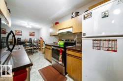 Kitchen featuring wood-finish cabinetry, dark countertops, and tile flooring - 