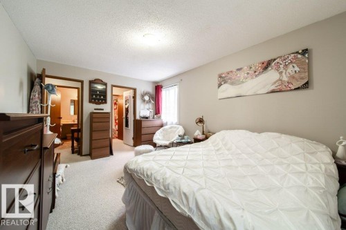 Neutral wall paint, ceiling-mounted light fixture, and textured carpeting - #307 6212 180 St Nw, Edmonton, AB - Indoor Photo Showing Bedroom