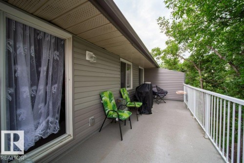 Spacious exterior balcony with a durable concrete surface, featuring a white railing, grey horizontal siding, and a soffit with integrated lighting - #307 6212 180 St Nw, Edmonton, AB - Outdoor With Deck Patio Veranda With Exterior