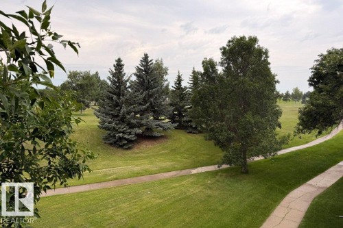 Expansive green space featuring mature trees and a paved pathway - #307 6212 180 St Nw, Edmonton, AB - Outdoor