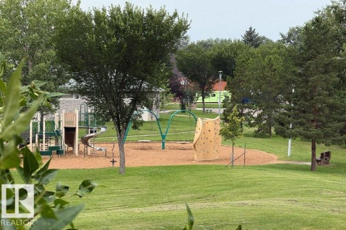 Community park featuring a play structure with slides, swings, and a rock-climbing wall - #307 6212 180 St Nw, Edmonton, AB - Outdoor