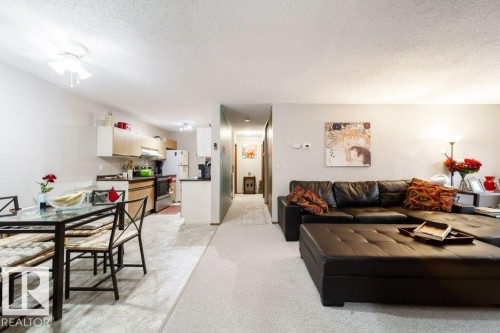Open-concept living space with distinct flooring zones - #307 6212 180 St Nw, Edmonton, AB - Indoor Photo Showing Living Room