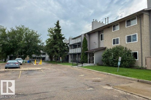 Multi-story residential building featuring a textured stucco exterior, multiple windows, and covered entrance - #307 6212 180 St Nw, Edmonton, AB - Outdoor