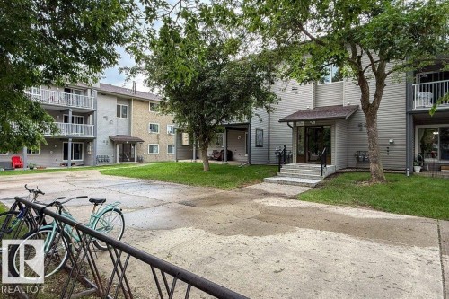 Multi-level building exterior featuring a covered entry, established landscaping, and private balconies - #307 6212 180 St Nw, Edmonton, AB - Outdoor