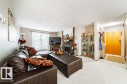 Living area featuring a brick fireplace with a wood mantle, a sliding glass door, and light-toned carpeting - 