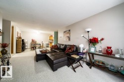 Spacious main living area featuring light-colored carpet flooring, neutral wall tones, and a textured ceiling - 