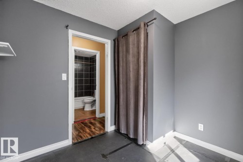 Interior space featuring gray walls, white trim, and dark flooring - 4003 41 Avenue Nw, Edmonton, AB - Indoor Photo Showing Other Room