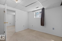Carpeted room with white walls, a single-pane window, and a drop ceiling - 