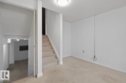 Carpeted room with white walls, baseboards, and a textured ceiling - 