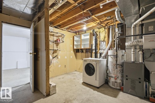 Unfinished basement space featuring exposed ceiling joists, concrete flooring, and a utility area with a water heater and furnace - 4003 41 Avenue Nw, Edmonton, AB - Indoor Photo Showing Laundry Room