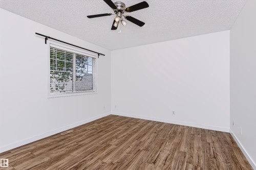 Room featuring wood-finish flooring, a window with blinds, a ceiling fan with light fixture, and white painted walls - #66 8304 11 Av Sw, Edmonton, AB - Indoor Photo Showing Other Room