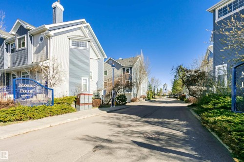 Multi-level townhome featuring varied siding textures, white trim accents, and multiple window styles - #66 8304 11 Av Sw, Edmonton, AB - Outdoor