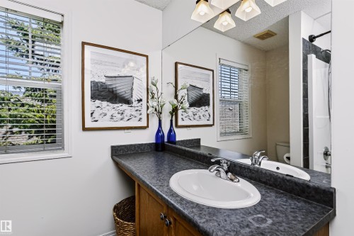 Bathroom vanity with a built-in sink, chrome fixtures, and a spacious countertop - #66 8304 11 Av Sw, Edmonton, AB - Indoor Photo Showing Bathroom