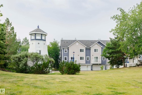 Lighthouse-inspired structure with white siding and an octagonal upper level with multiple windows - #66 8304 11 Av Sw, Edmonton, AB - Outdoor