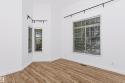 Spacious room featuring vaulted ceilings, a prominent large window, and an additional bay window array - 