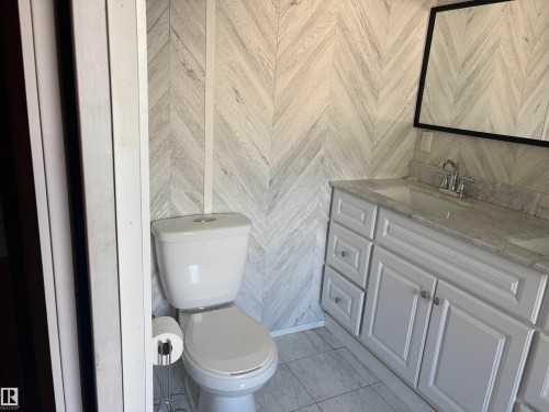 Bathroom featuring a light-toned chevron pattern wall treatment. dual vanity - 4620 Maria Drive, Smoky Lake Town, AB - Indoor Photo Showing Bathroom