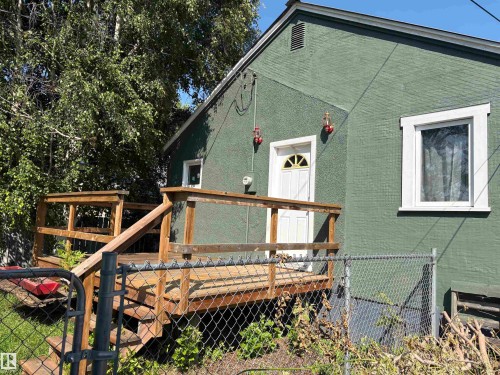 Green textured exterior with white trim windows and a white entry door - 4620 Maria Drive, Smoky Lake Town, AB - Outdoor With Deck Patio Veranda