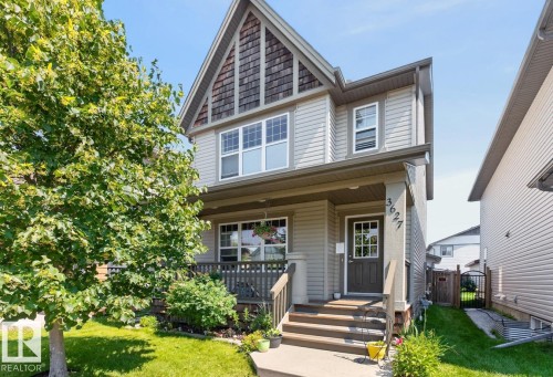 Two-story home with light gray siding, dark wood-look porch railings, and a prominent gable with wood shingle accents - 3627 12 Street Nw, Edmonton, AB - Outdoor With Deck Patio Veranda
