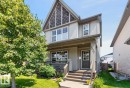 Two-story home with light gray siding, dark wood-look porch railings, and a prominent gable with wood shingle accents - 3627 12 Street Nw, Edmonton, AB  - Outdoor With Deck Patio Veranda 