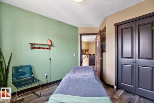 Neutral-toned wood-finish flooring complements the room's accent wall - 3627 12 Street Nw, Edmonton, AB - Indoor Photo Showing Bedroom