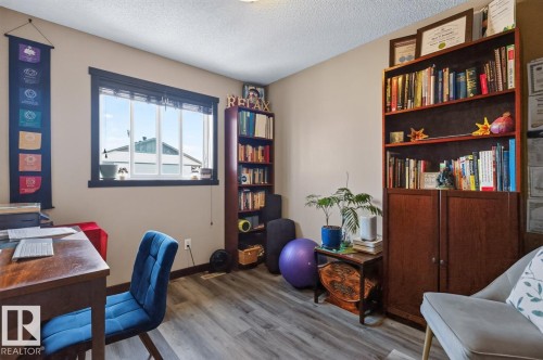 Interior room featuring light gray wood-finish flooring, a neutral wall color, and a large window with black trim - 3627 12 Street Nw, Edmonton, AB - Indoor Photo Showing Office