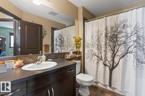 Bathroom featuring a dark wood-finish vanity with an oval undermount sink, a large mirror, a toilet, and a shower with a white and black decorative shower curtain - 3627 12 Street Nw, Edmonton, AB - Indoor Photo Showing Bathroom