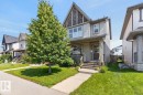 Two-story residence featuring light gray siding with white trim accents and a prominent front gable with decorative shingle siding - 3627 12 Street Nw, Edmonton, AB  - Outdoor With Deck Patio Veranda With Facade 