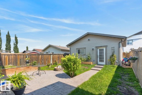 Backyard featuring a stamped concrete patio, a stone fire pit, and a privacy fence - 3627 12 Street Nw, Edmonton, AB - Outdoor