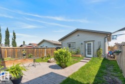 Backyard featuring a stamped concrete patio, a stone fire pit, and a privacy fence - 