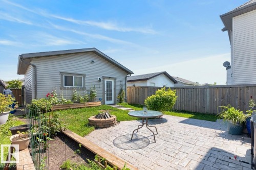 Expansive backyard featuring a stamped concrete patio, a stone fire pit, and a detached building with siding exterior - 3627 12 Street Nw, Edmonton, AB - Outdoor