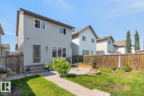 Private backyard featuring a paved patio area with a built-in fire pit, raised garden bed, and wood privacy fencing - 3627 12 Street Nw, Edmonton, AB - Outdoor