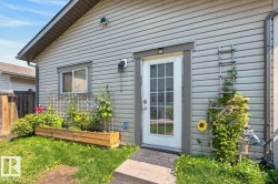 Vinyl-sided exterior featuring a glass-paned door with white trim - 