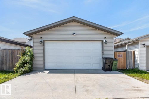 Attached garage featuring a white panel door, light-colored siding, and a gabled roofline - 3627 12 Street Nw, Edmonton, AB - Outdoor With Exterior