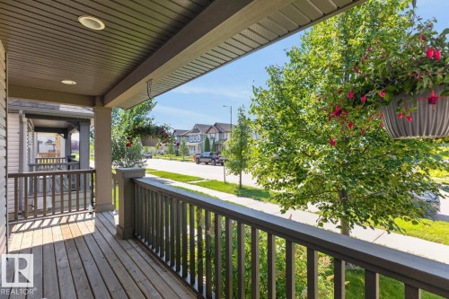 Inviting front porch featuring wood-finish decking and dark-toned railings - 3627 12 Street Nw, Edmonton, AB - Outdoor With Deck Patio Veranda With Exterior