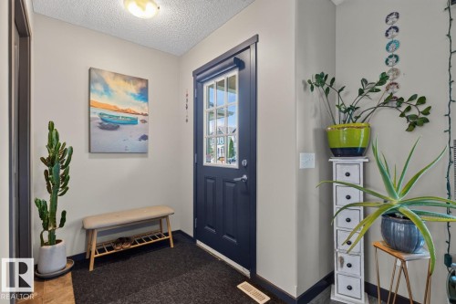 Entryway featuring a dark paneled door with glass inserts, neutral wall color, and a textured ceiling - 3627 12 Street Nw, Edmonton, AB - Indoor Photo Showing Other Room