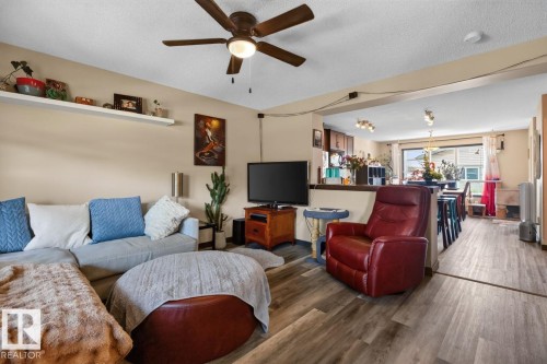 Living area with wood-finish flooring, a ceiling fan, and a neutral color palette - 3627 12 Street Nw, Edmonton, AB - Indoor Photo Showing Living Room